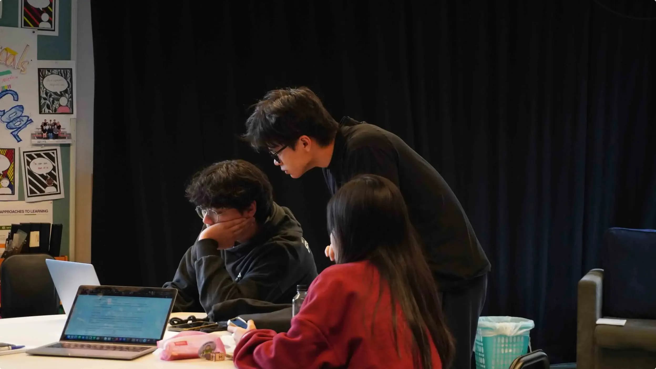 3 students working on a project together in a classroom